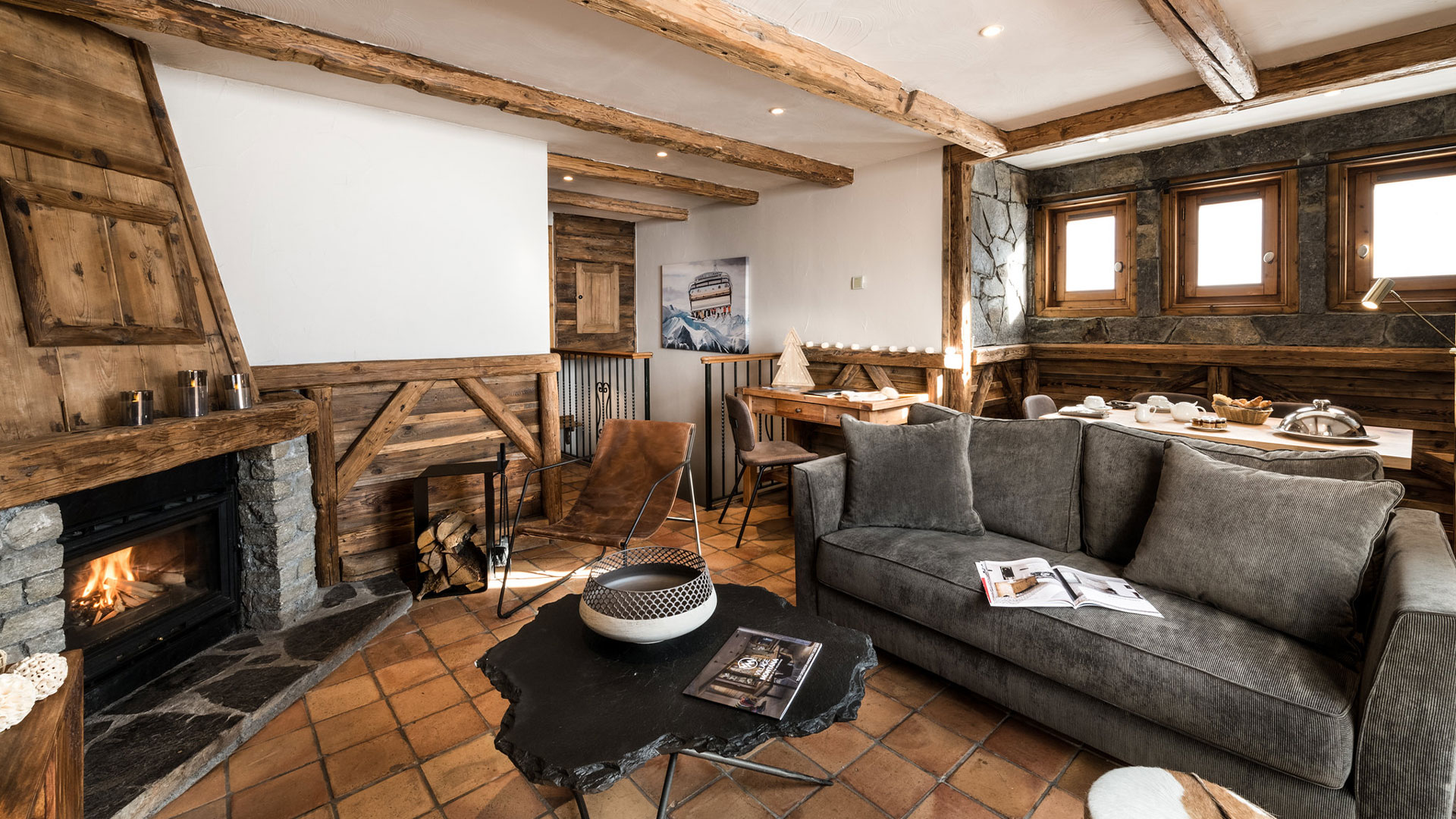 Salon et chambre sous poutres aux Suites du Montana à Tignes, avec cheminée en pierre
