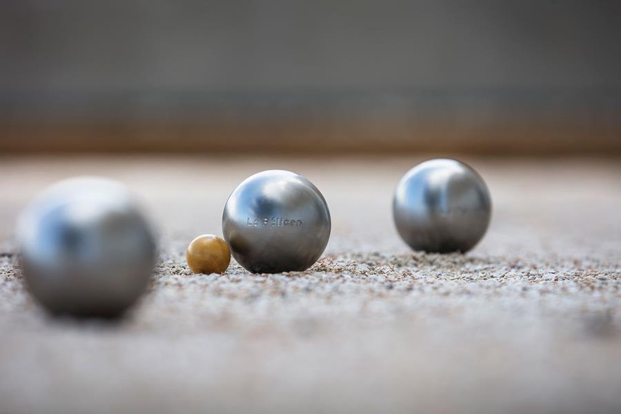 Boules et cochonnet sur le terrain de pétanque de l'hôtel Le Pélican à Annecy.