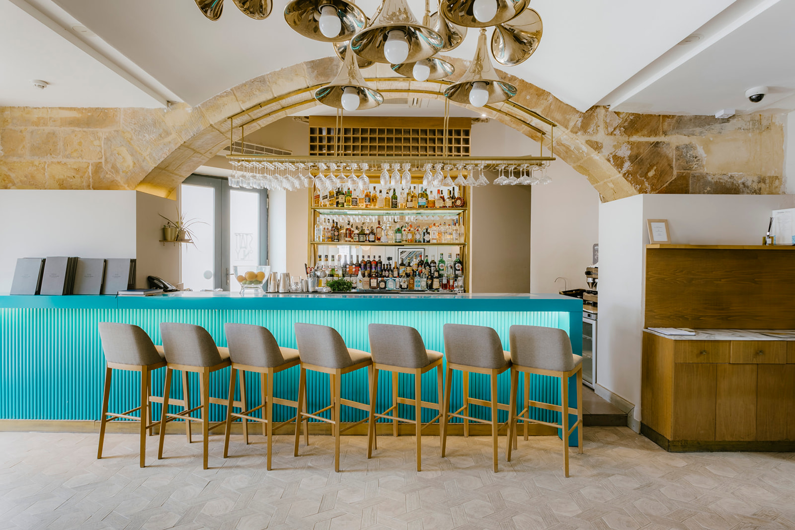 Bar aux tabourets turquoise sous les arches du Cugó Gran Macina, à Senglea sur l'île de Malte.