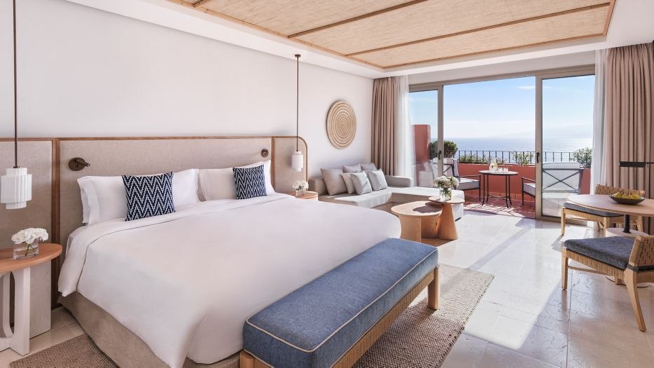 Chambre de l'Abama avec lit double, textiles clairs et mobilier en bois.