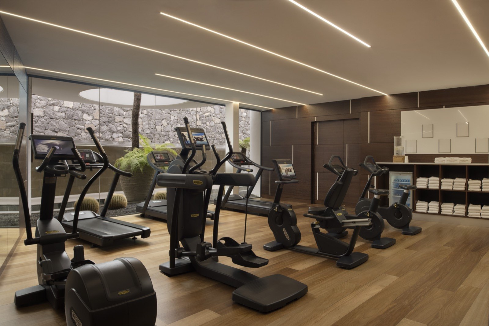 Salle de fitness du Corales Resort équipée de machines face aux baies vitrées.