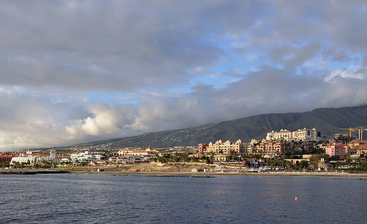 La côte de Costa Adeje vue depuis la mer, avec les reliefs de Tenerife à l'arrière-plan.