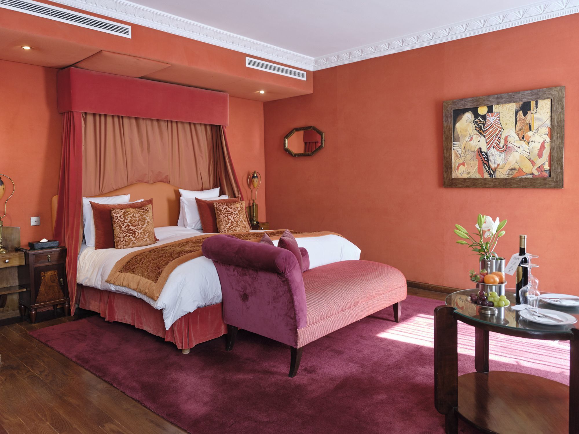 Chambre rouge de l'Hôtel Le Doge à Casablanca, avec rideaux autour du lit et méridienne rose.