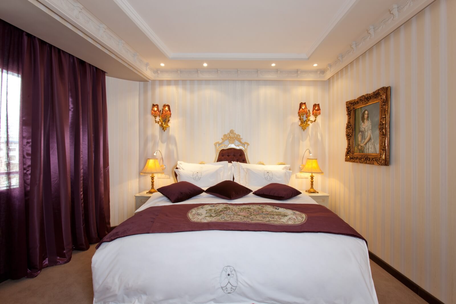 Chambre à lit blanc et rideaux violets à l'Art Palace Suites & Spa, dans le quartier Gauthier de Casablanca.