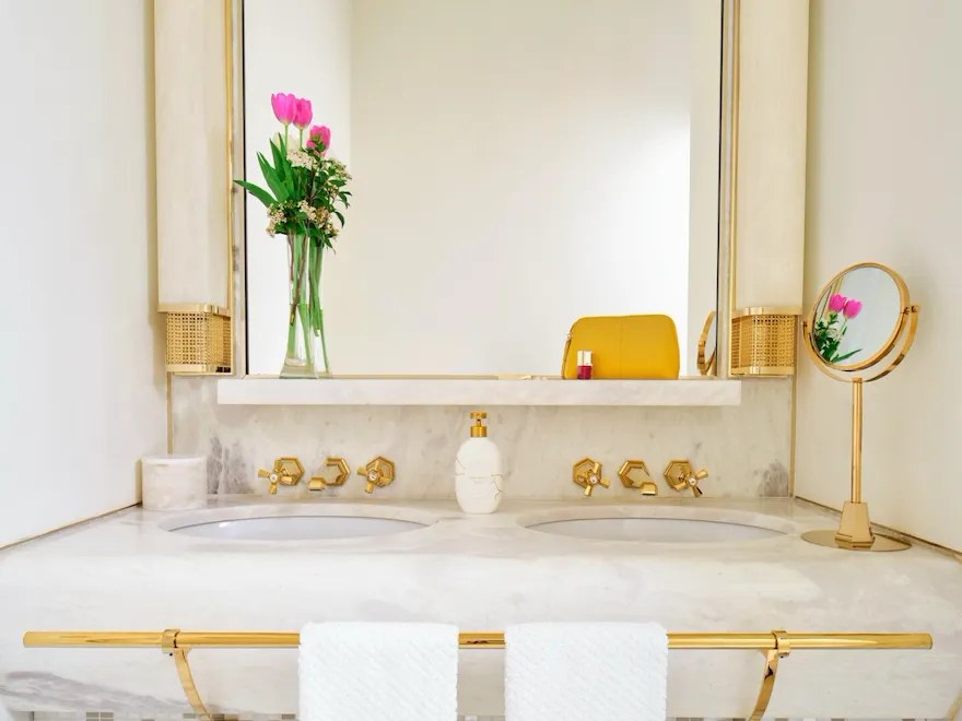 Salle de bains de l'Hotel Eden à Rome, marbre clair et vasque sous le miroir.