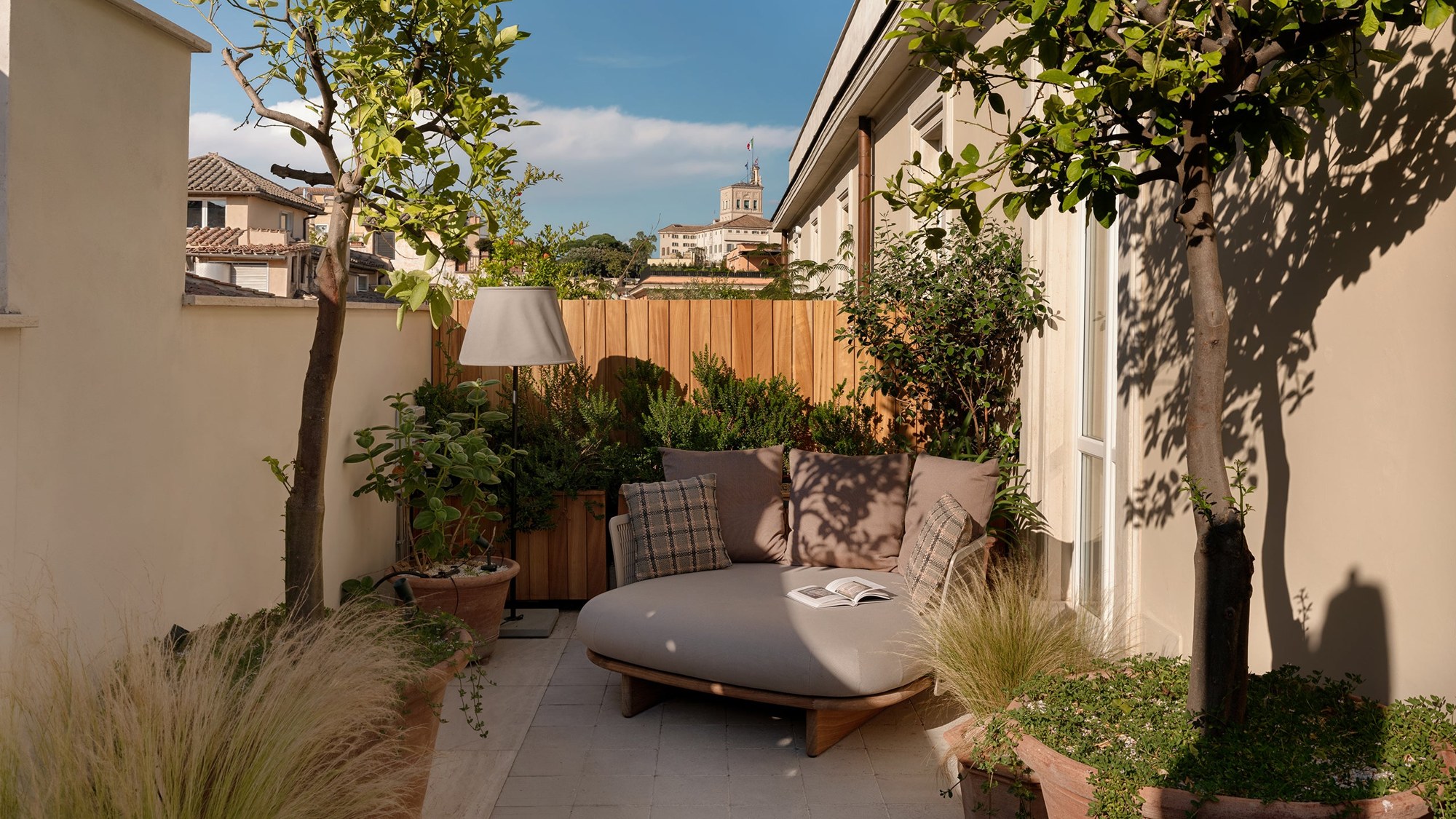 Terrasse privée d'une Terrace Junior Suite du Six Senses Rome, avec fauteuil et plantes.