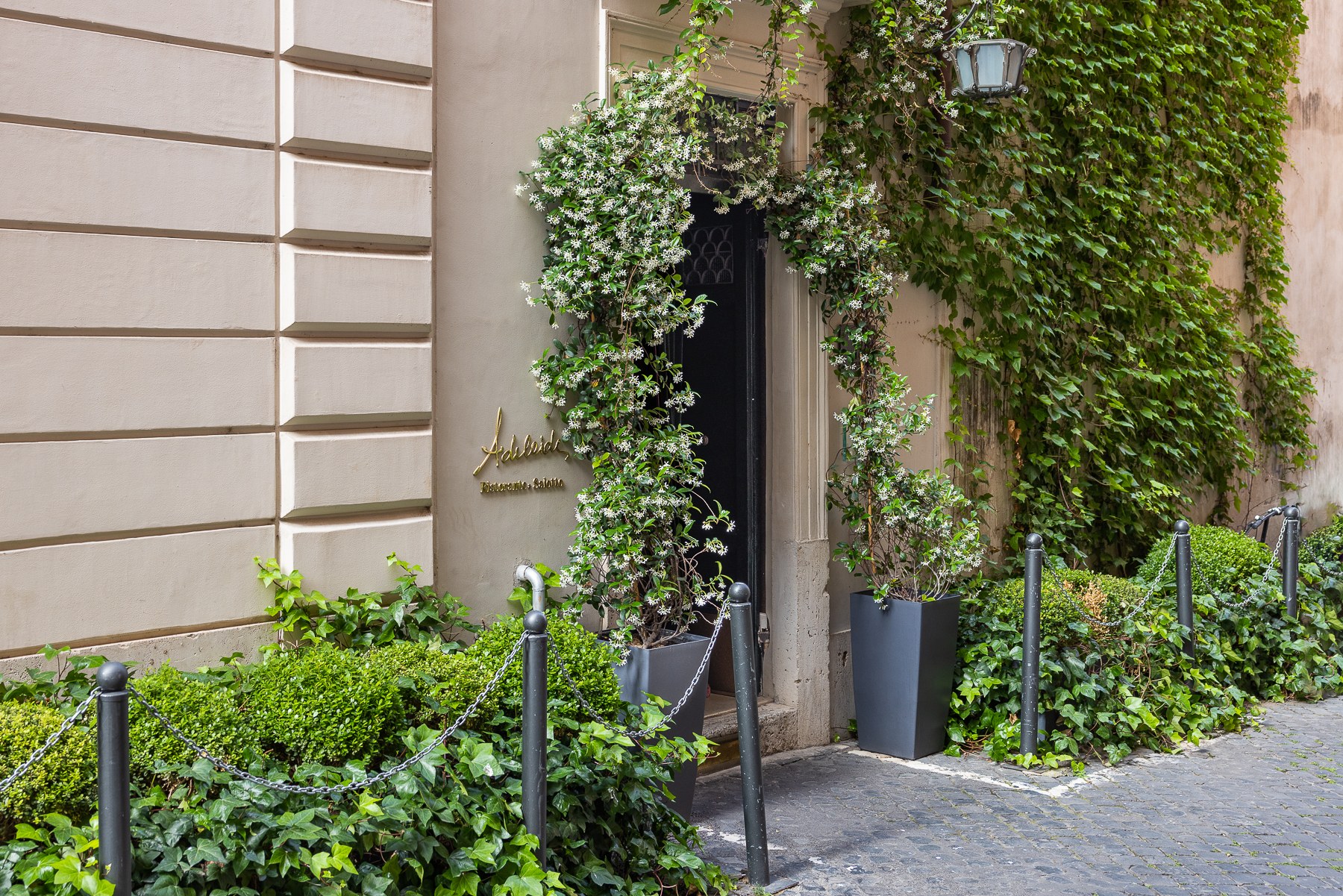 Porte ouverte sur le patio planté de l'Hotel Vilòn à Rome.