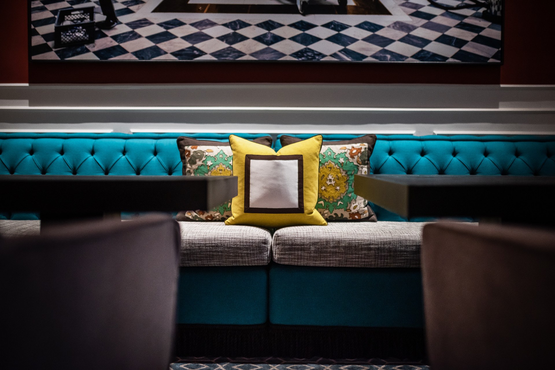 Banquette capitonnée et décor géométrique dans les espaces de l'Hotel Vilòn à Rome.