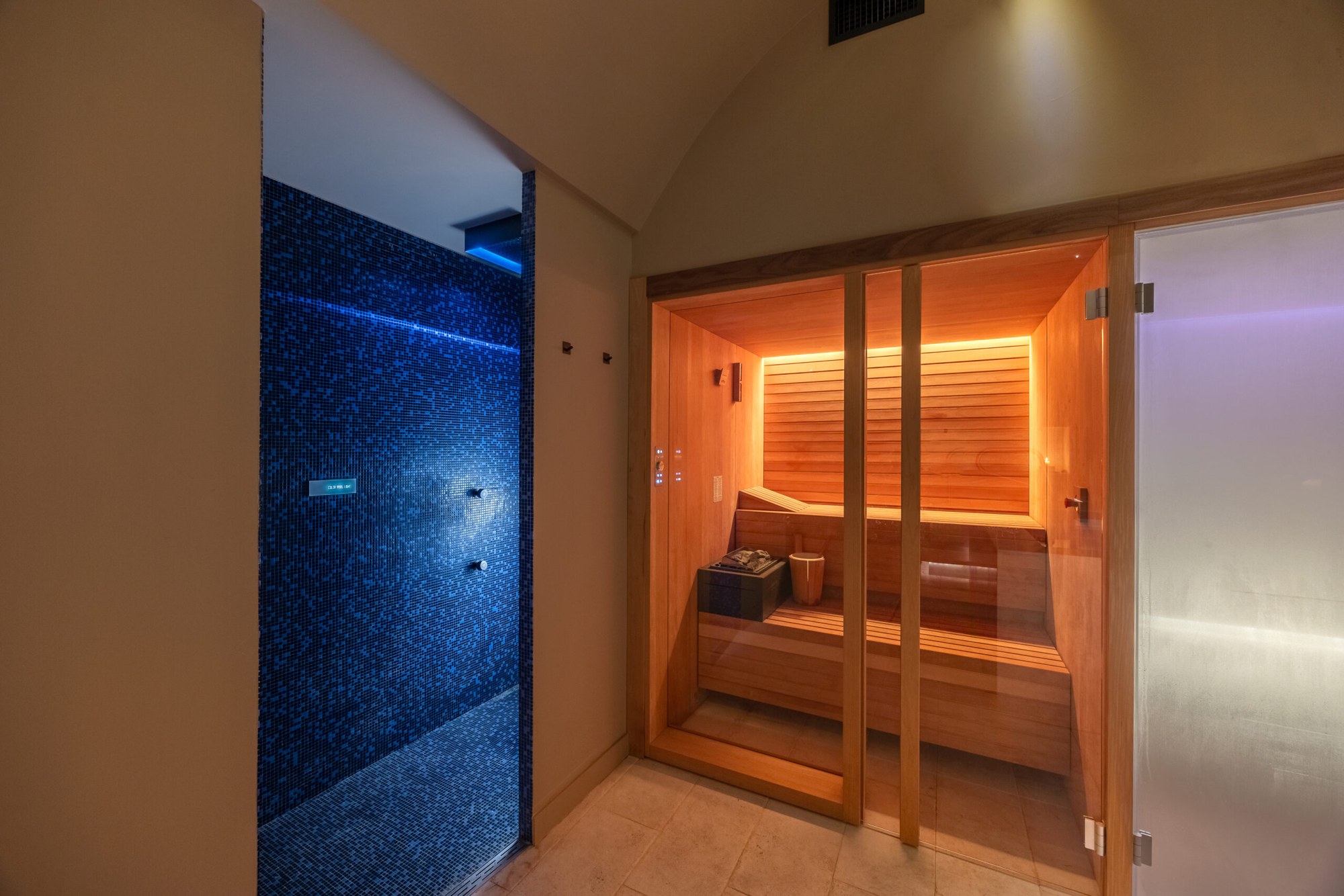 Sauna de DAHAM SPA au Palazzo Dama à Rome, éclairé derrière une porte vitrée.