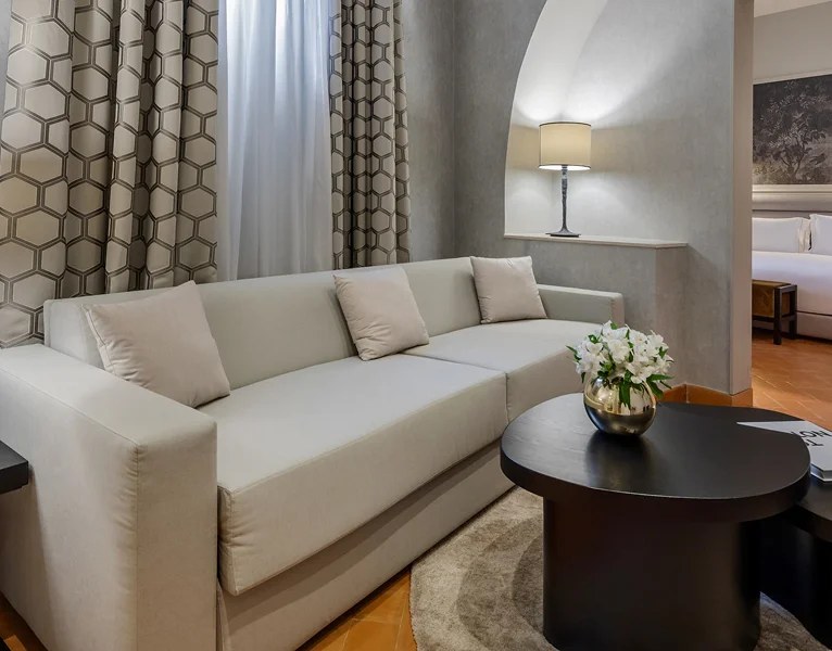 Salon d'une suite de Donna Camilla Savelli à Rome, canapé clair et table basse.