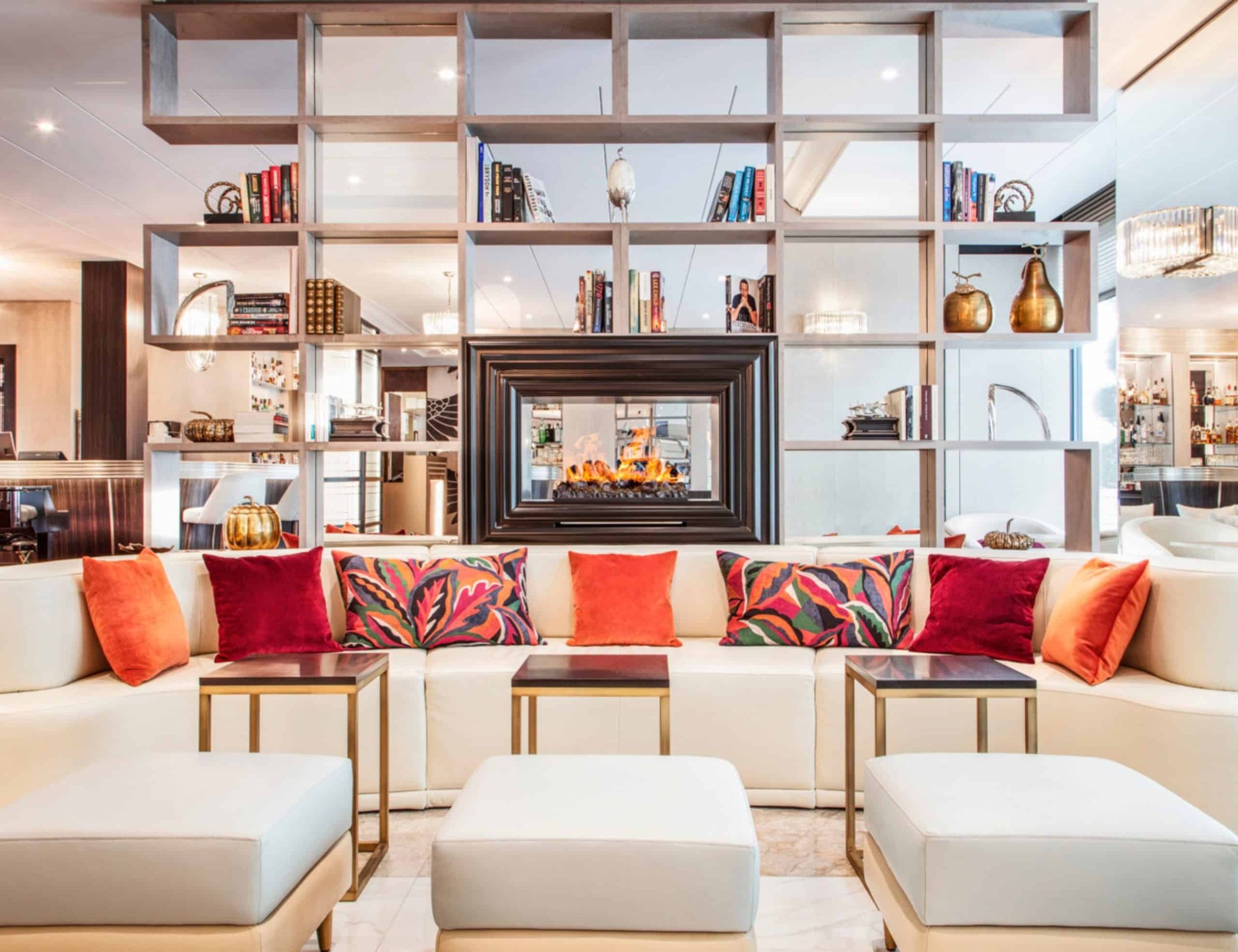 Le salon du Bristol, avec cheminée et fauteuils clairs - Hôtel Bristol, Genève.