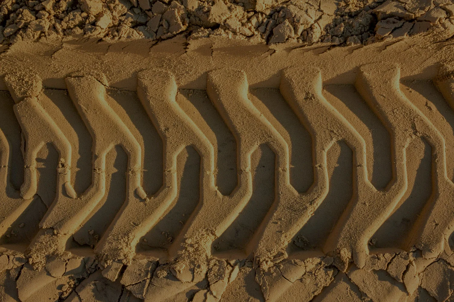 Machine track marks pressed into sand at a Platinum site