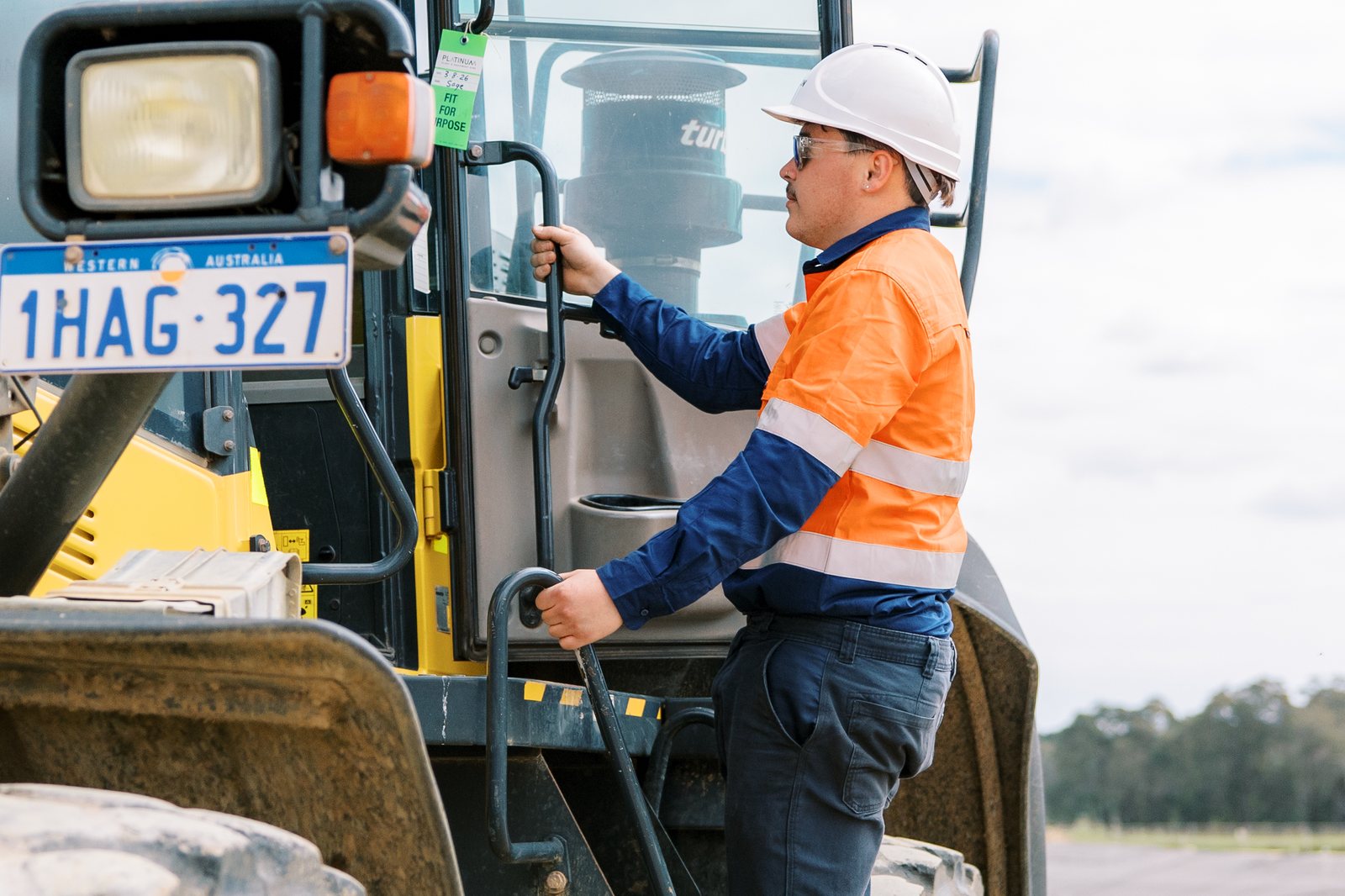 Platinum operator climbing into the cab of a Komatsu wheel loader on site