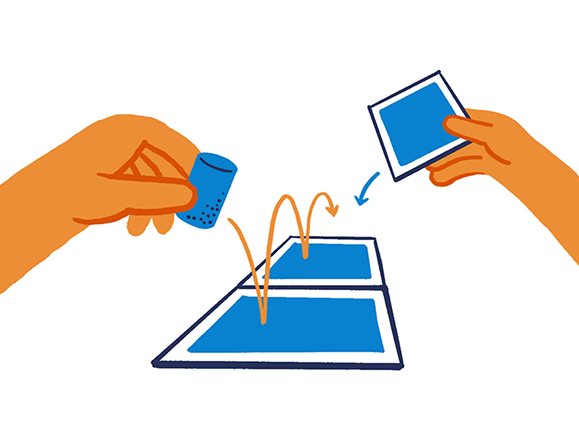 Hands playing a game where a small blue item is bounced on blue cards arranged on a white surface.
