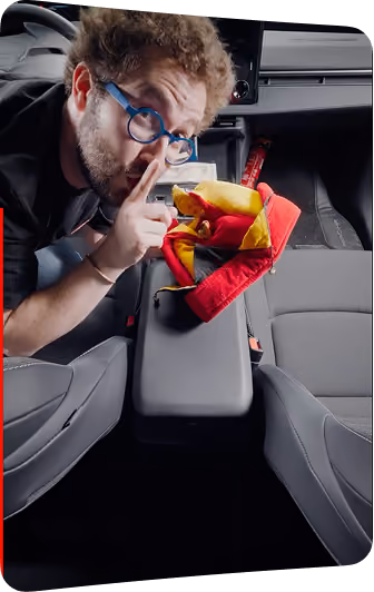 blue2purple - A man leaning into a car cabin holding a snack, making a quiet gesture