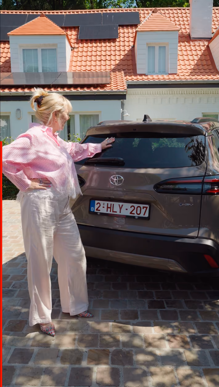 blue2purple - A woman in a pink shirt standing beside a brown Toyota SUV on a cobbled driveway