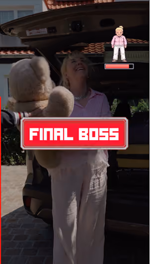 blue2purple - A woman carrying a large teddy bear to a car boot with a game style Final Boss caption