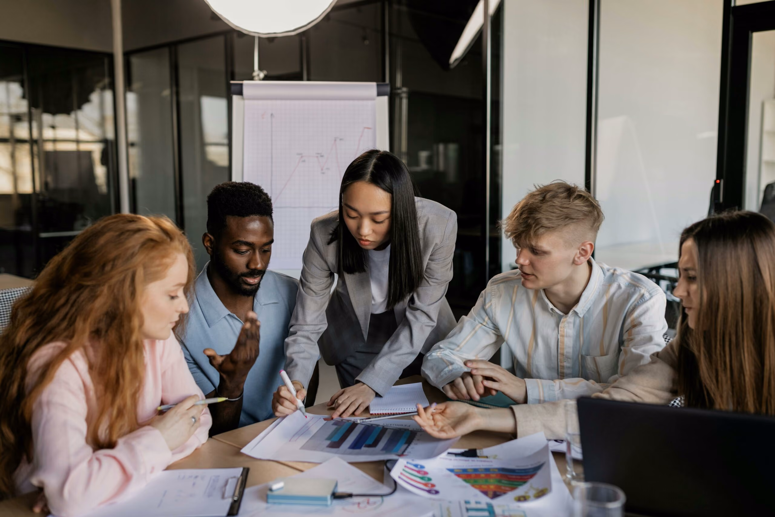blue2purple - Diverse marketing team reviewing charts together around a table