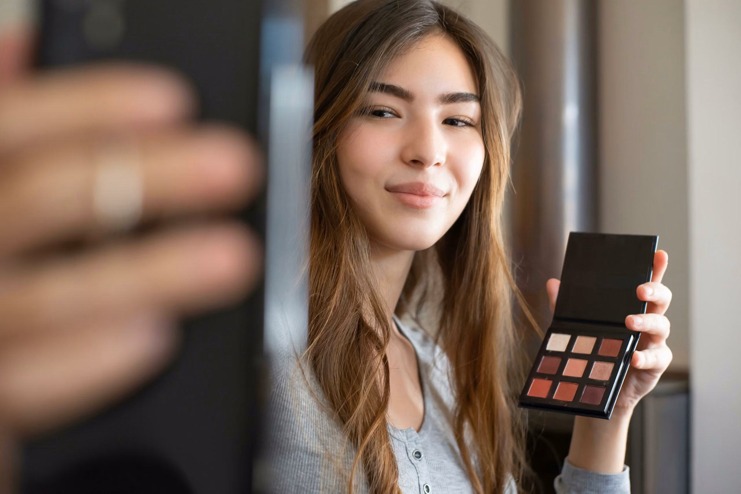 blue2purple - Woman taking a selfie while holding a makeup palette