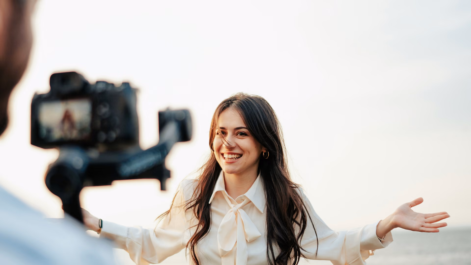blue2purple - Smiling woman speaking to a camera on a gimbal outdoors