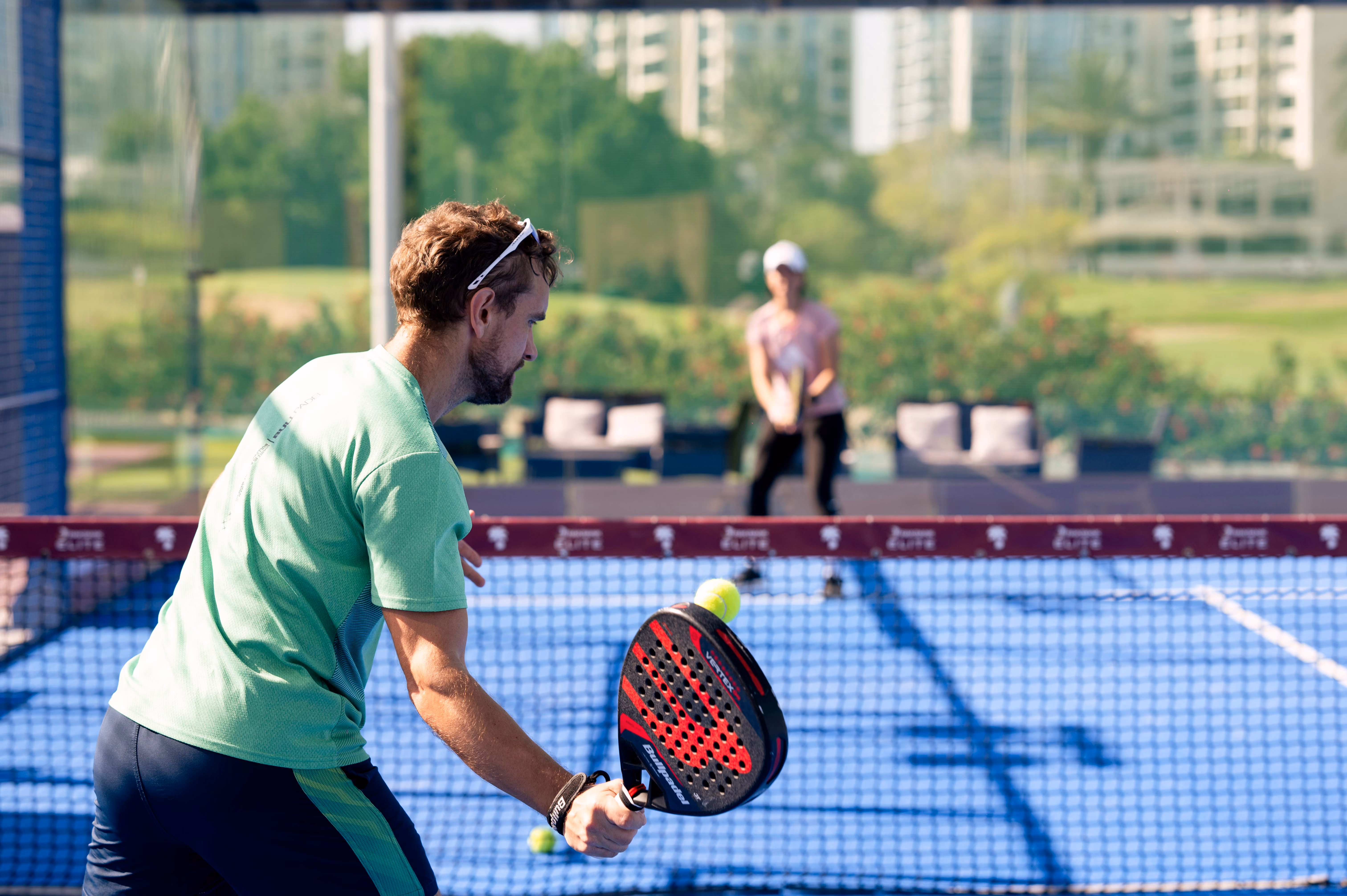 Padel coach preparing to play a shot during an outdoor training session