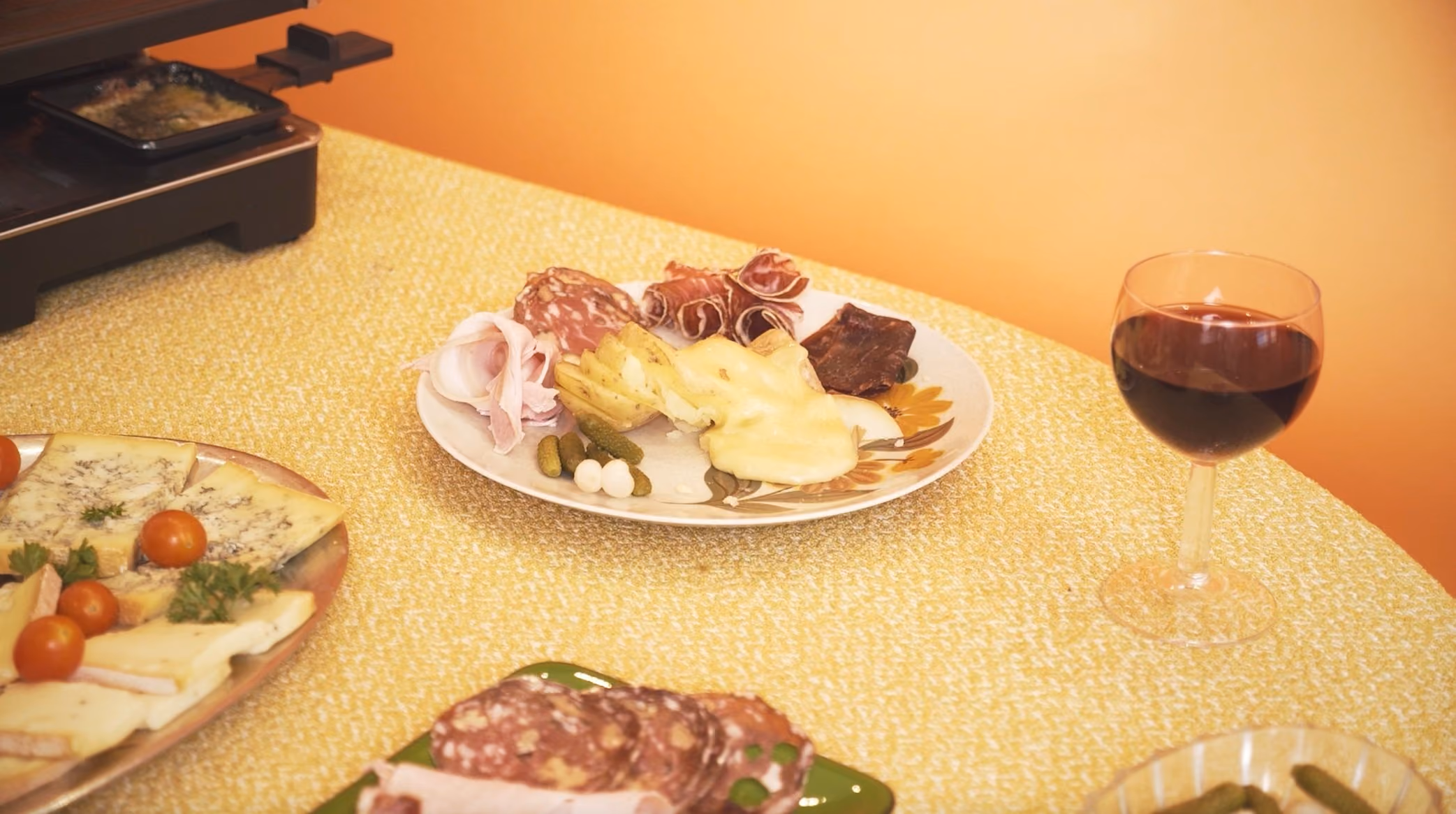 Verres de vin blanc et rouge à côté d'une raclette