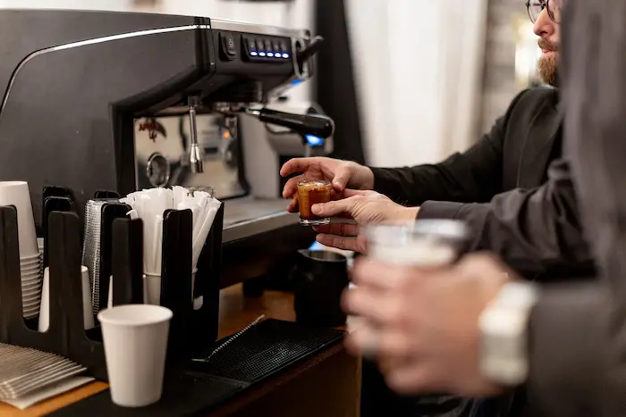 Barista holding a fresh espresso shot at the coffee station