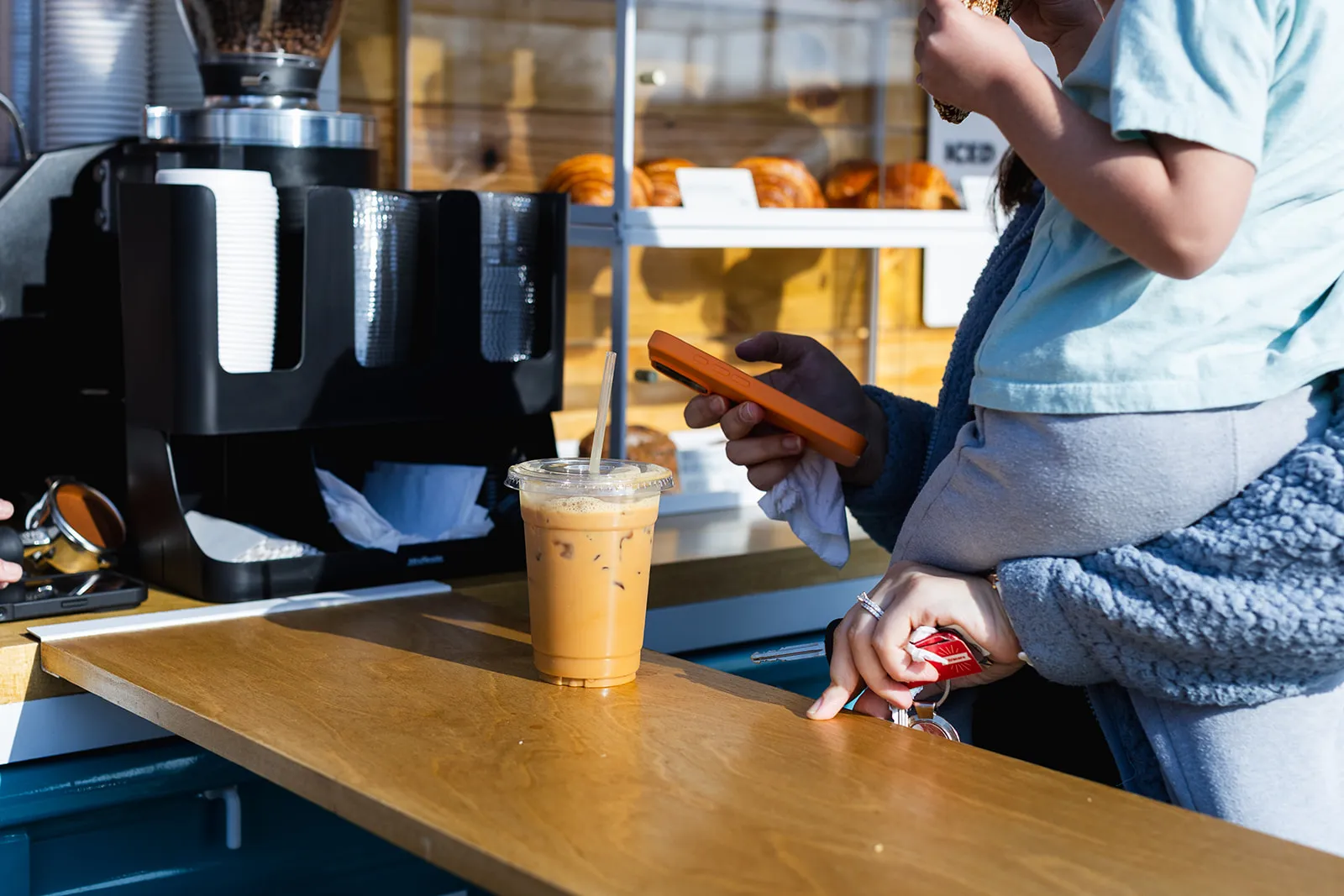 Iced coffee handed across the wooden truck counter