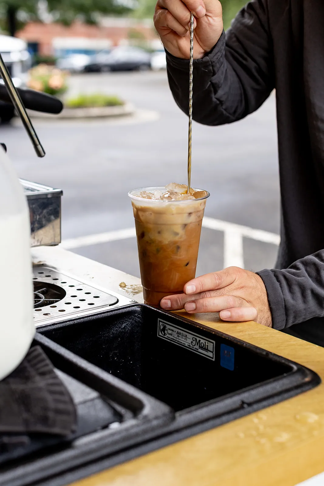 Barista stirring an iced latte on the truck counter