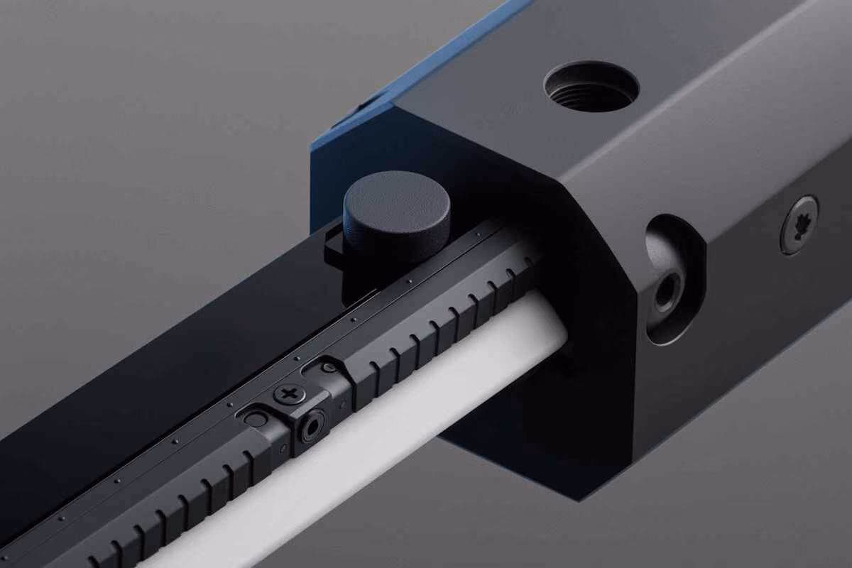 Close-up of a black metal lock mechanism with a knob and serial markings on a gray background.