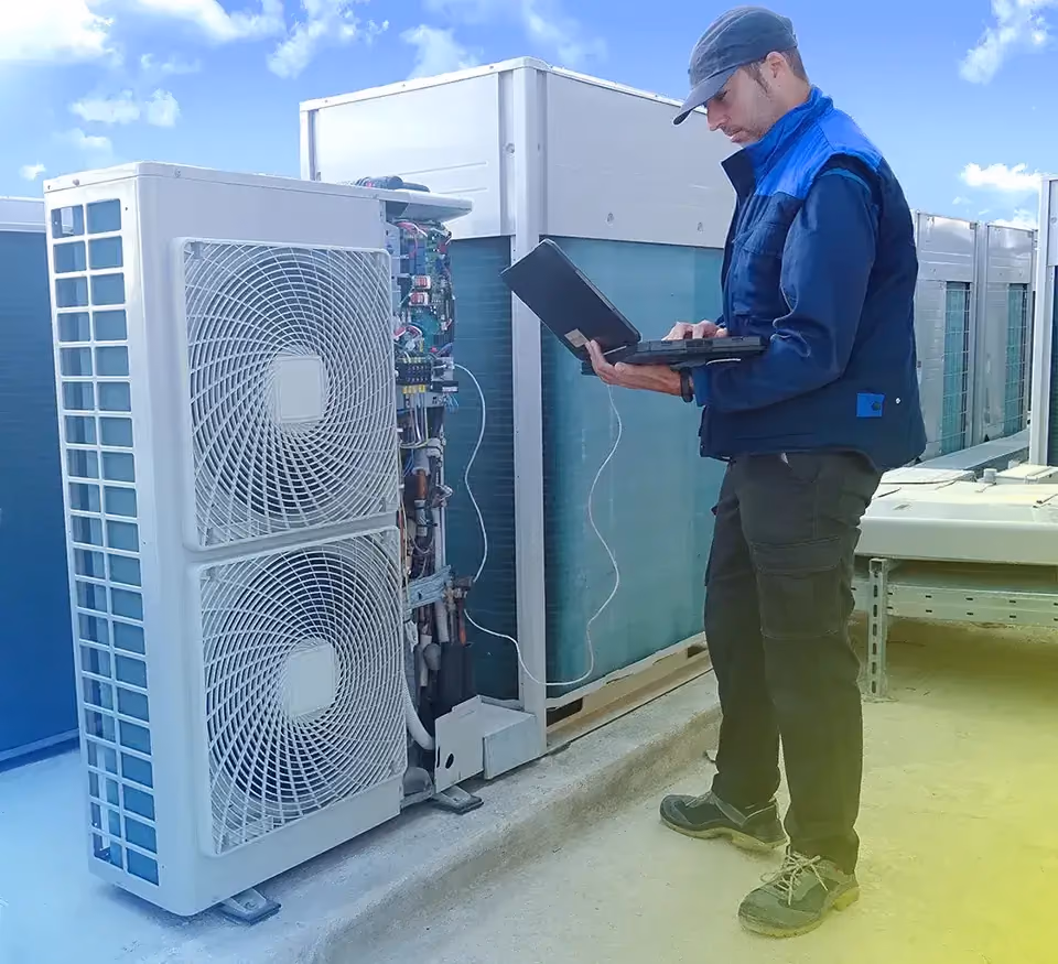Technicien avec tablette près d'unités de climatisation en toiture