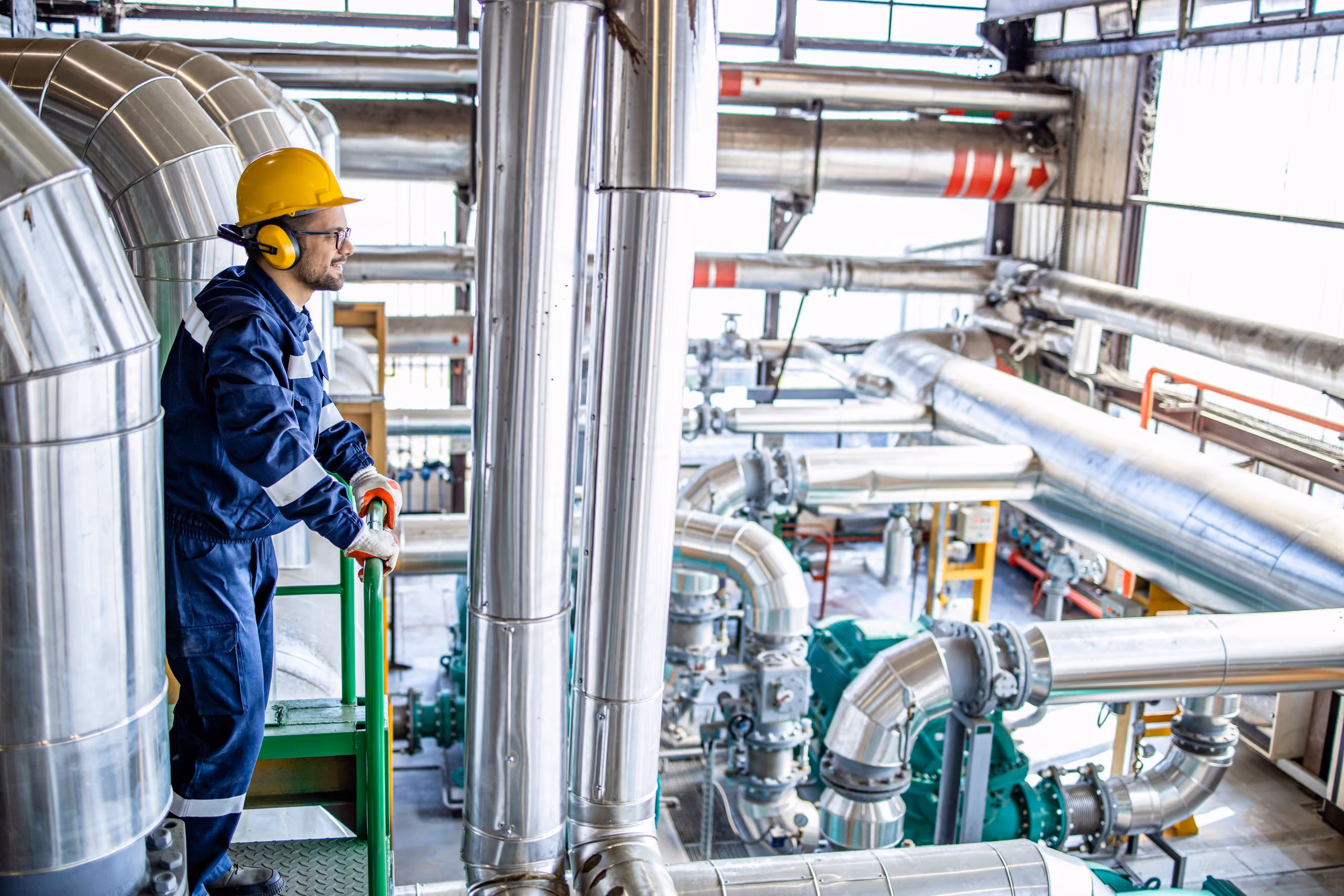 Technicien en casque et tenue de travail dans une installation industrielle