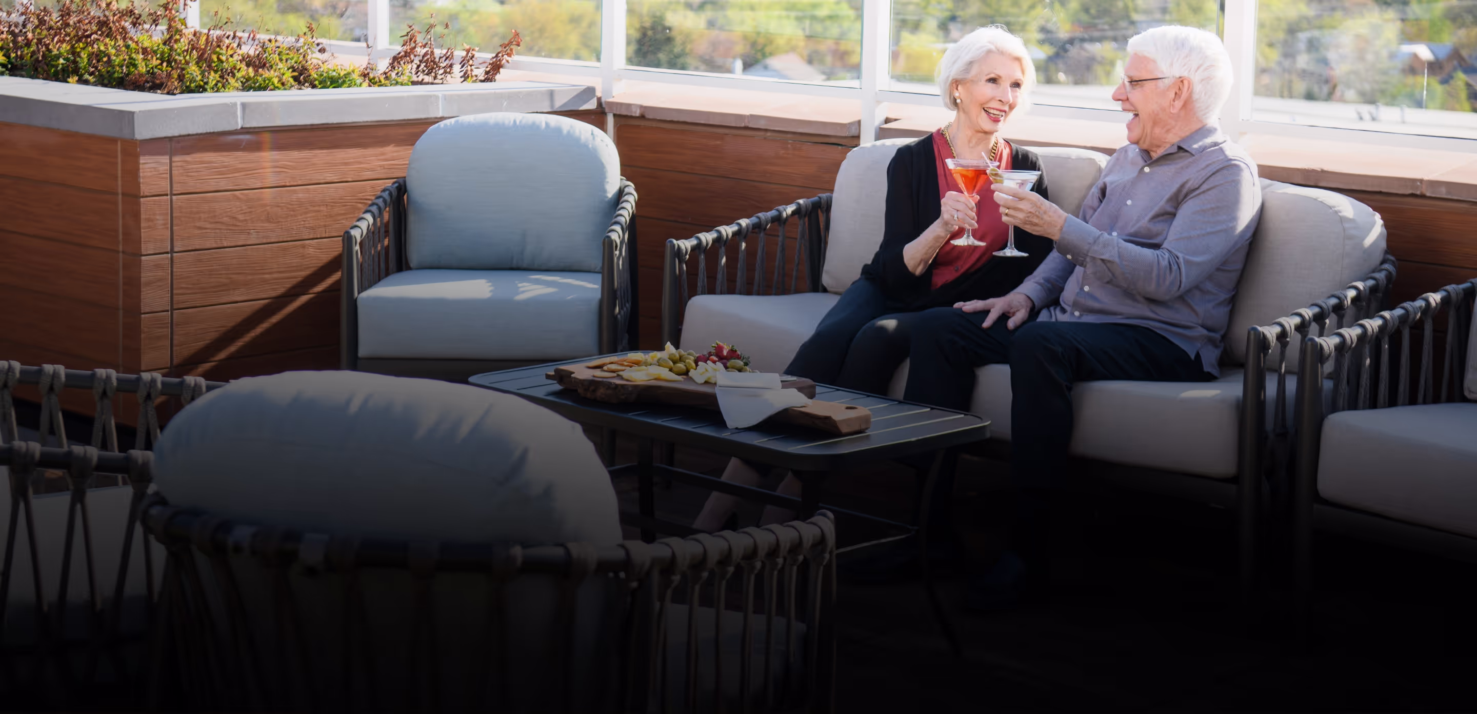 senior residents enjoying cocktails together outside on the patio