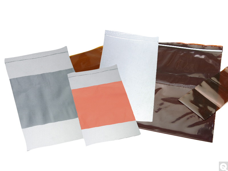 An assortment of wholesale plastic bags, including white and coloured open end bags and clear and amber zip bags.