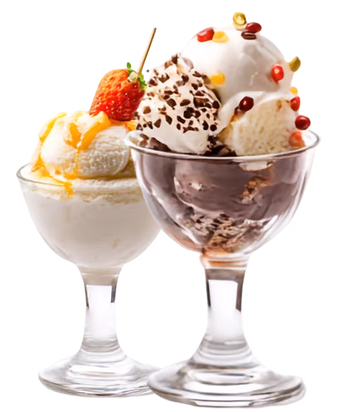 Two glass dessert cups with vanilla ice cream topped with strawberry, whipped cream, chocolate, and fruit bits.