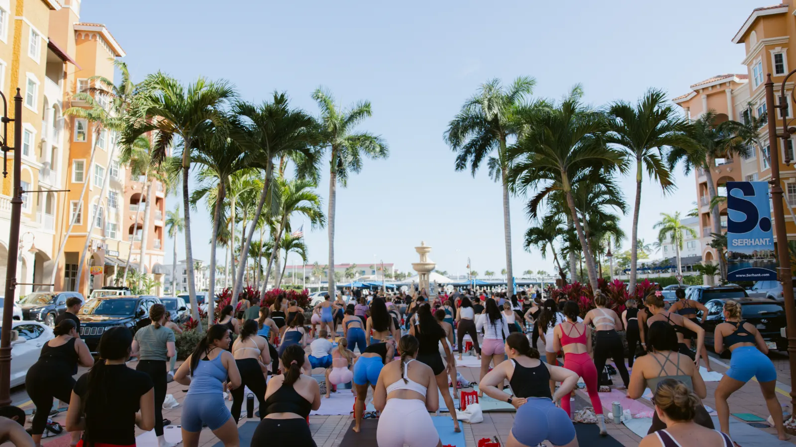 Hundreds of people on mats at an outdoor Sculpted class at Bayfront Place, Naples