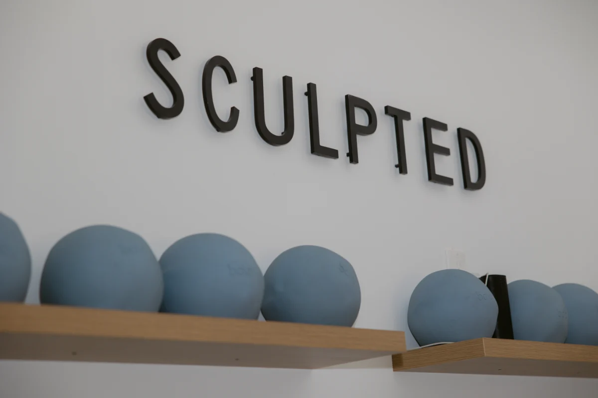 The Sculpted wordmark mounted on a white studio wall