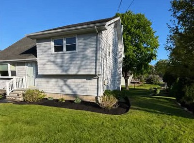 Clean flower bed with fresh dark organic mulch and crisp lawn edging by a Westerly landscaper.