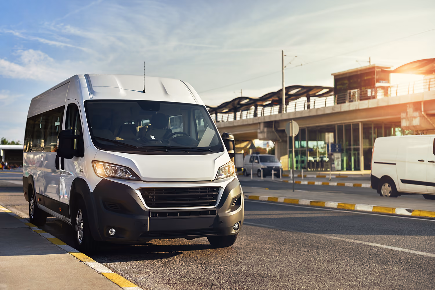 Airport shuttle van parked outside an airport transit station