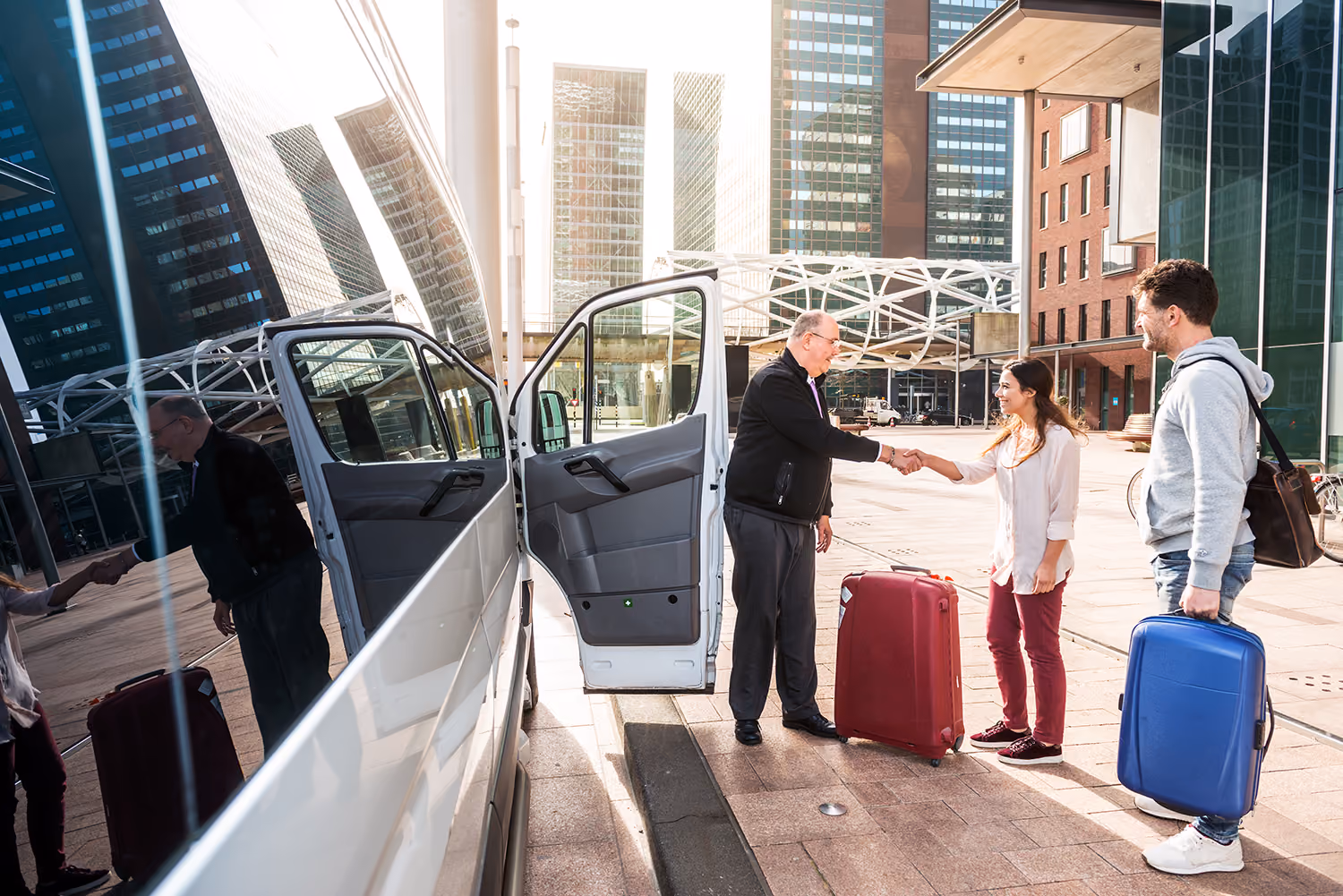 Shuttle driver with passengers beside a van in the city