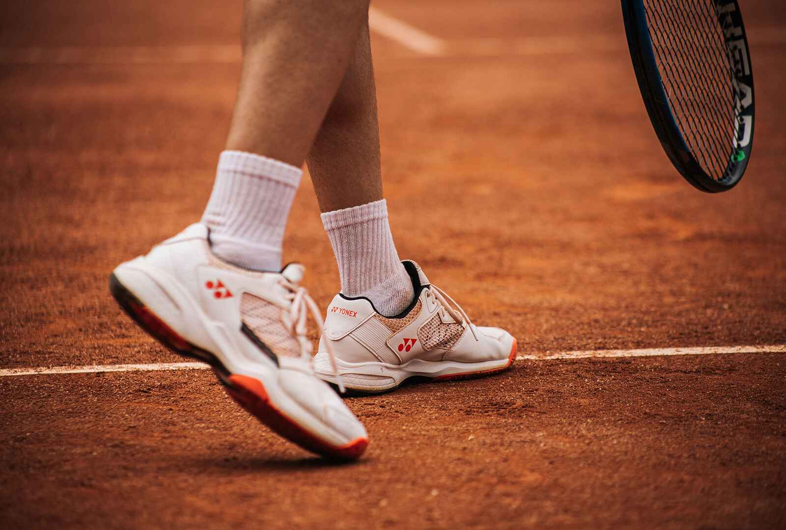 A badminton player ready to serve the shuttle.