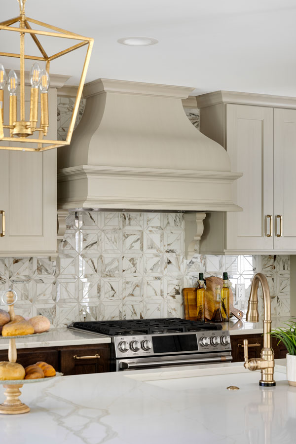Custom warm white range hood and tile backsplash