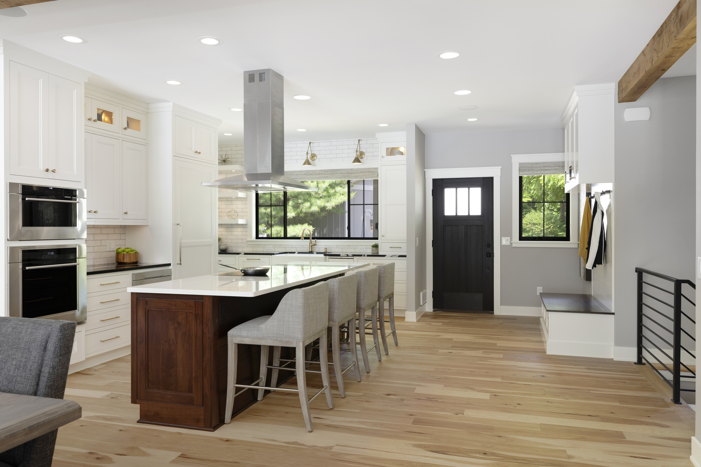 Kitchen remodel with large wooden island and white surrounding cabinets