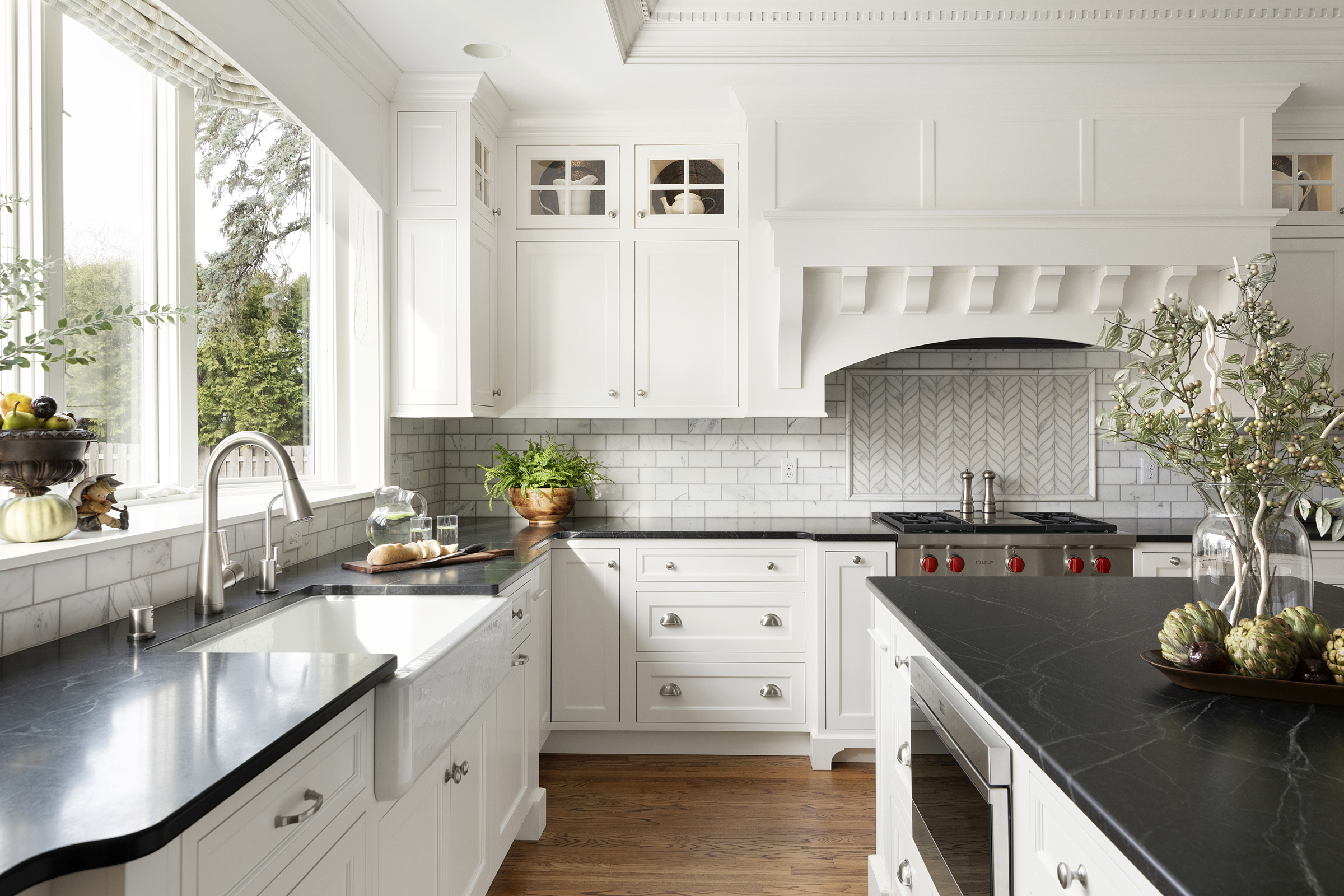 Kitchen remodel with large wooden island and white surrounding cabinets