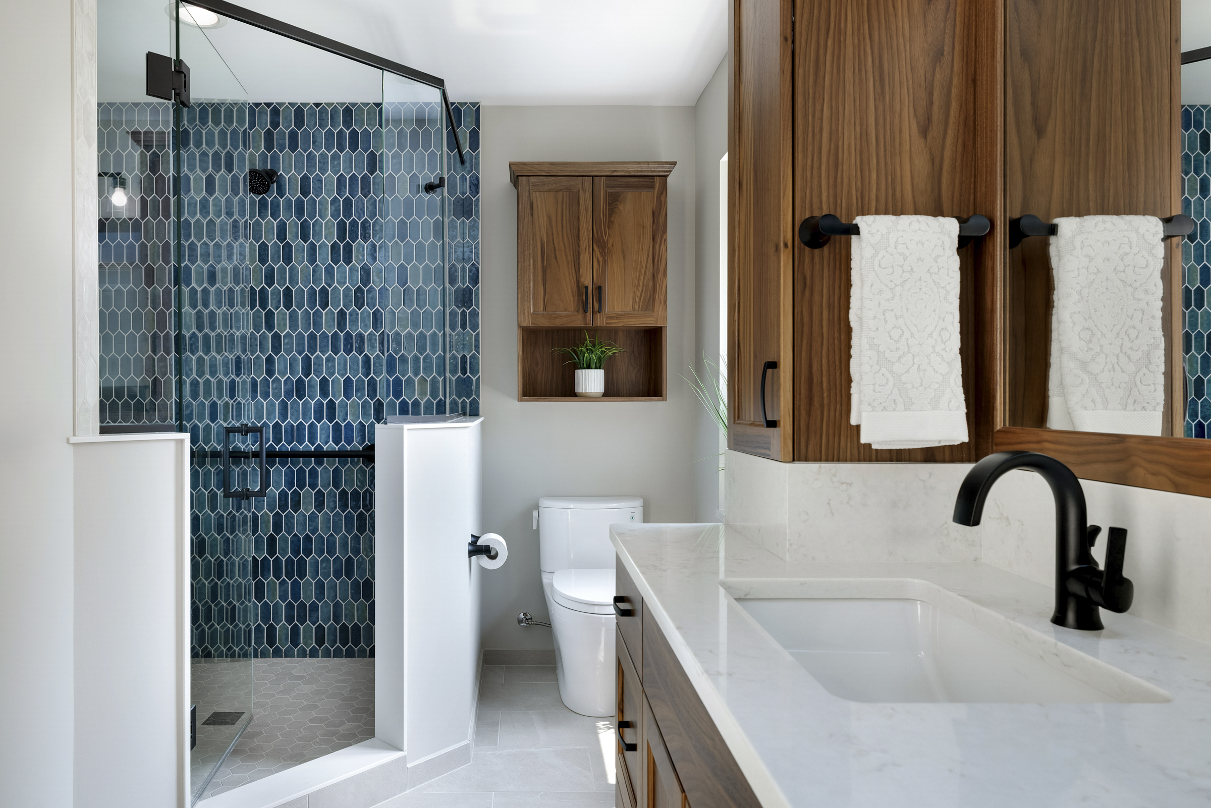European inspired bathroom remodel with light blue vanity and white tile floor