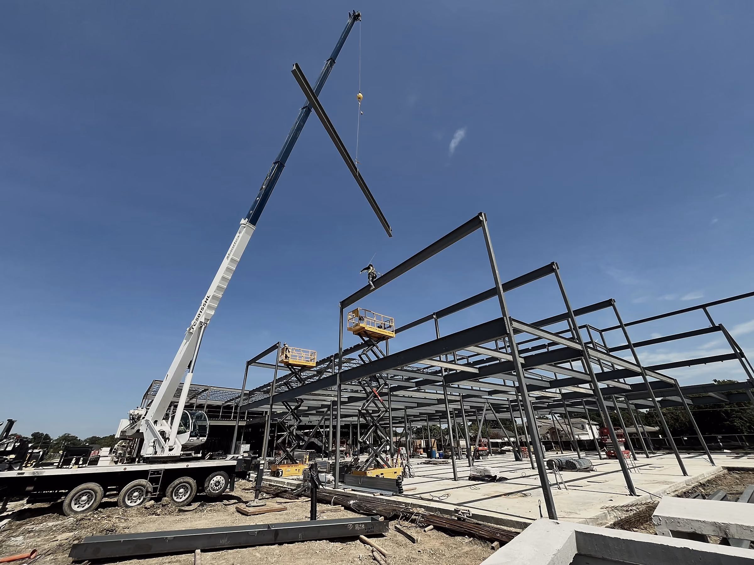 Structural steel frame of a commercial building at sunset on a Collin County jobsite