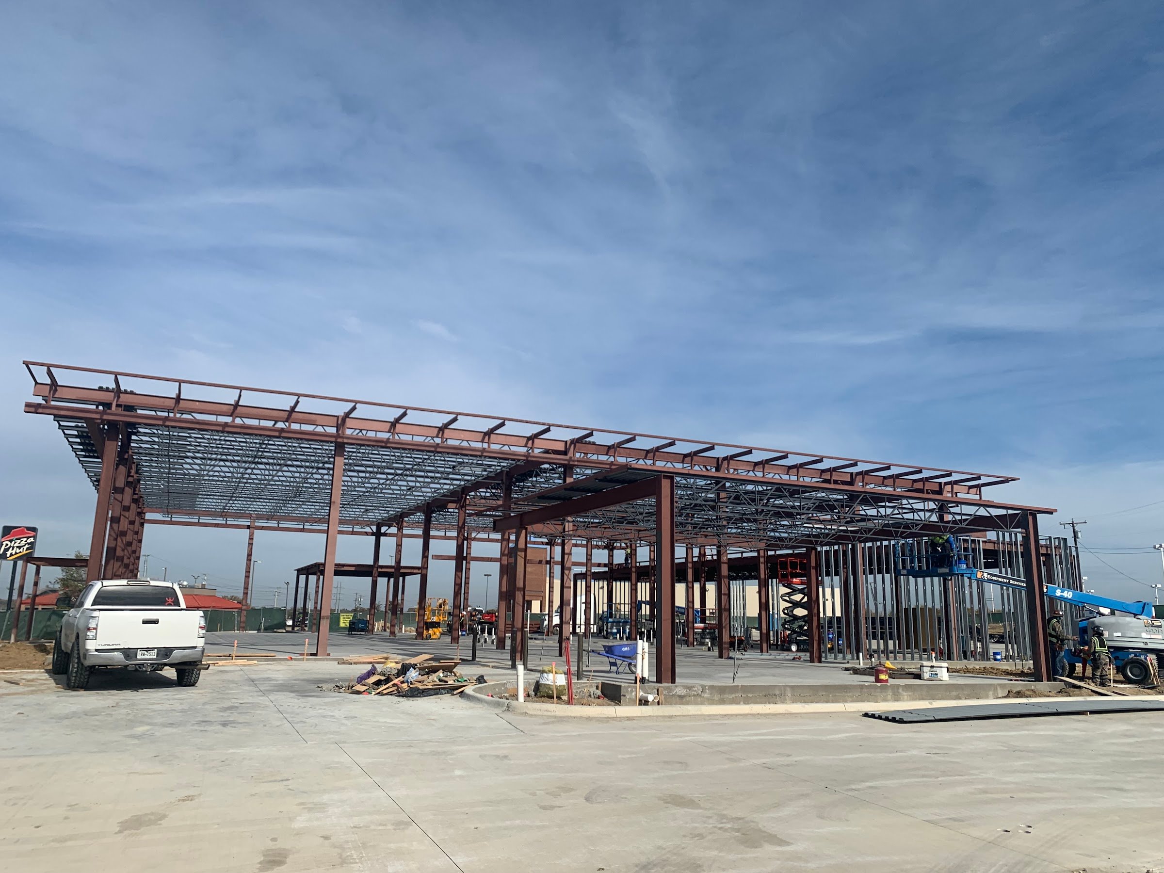 Two-story structural steel frame of a dealership showroom with canopy framing