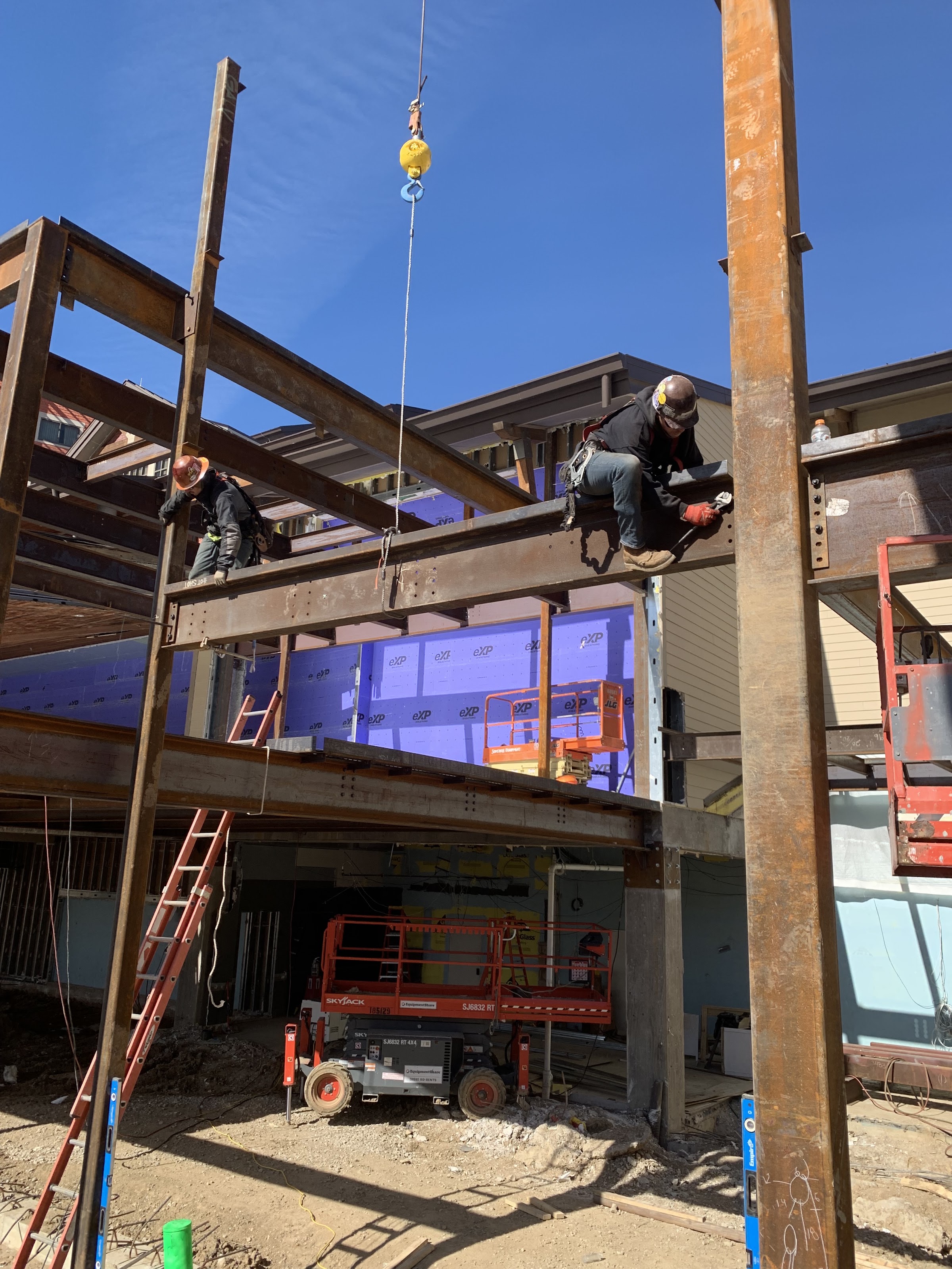Ironworker setting a beam on an exterior addition