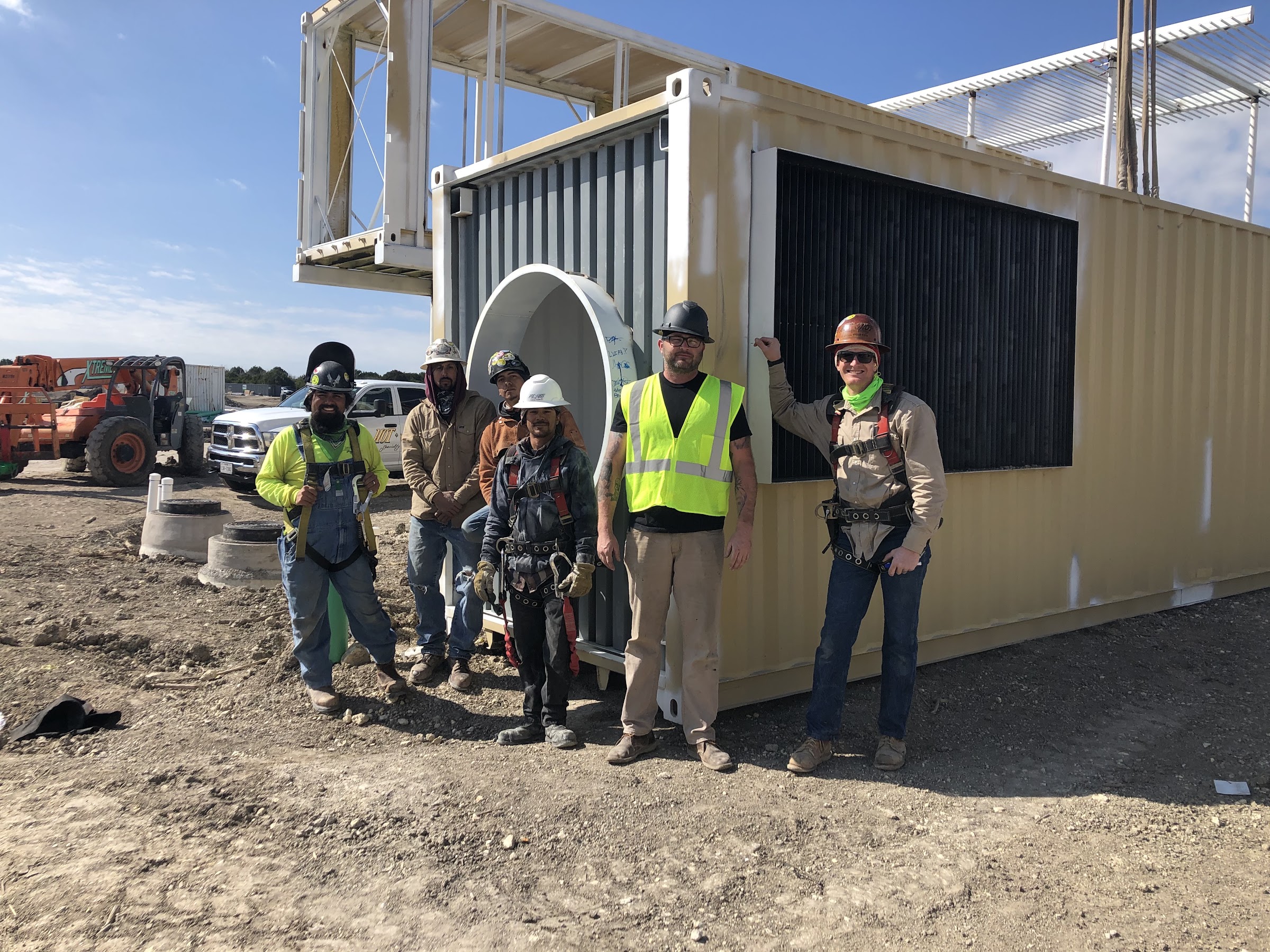 Crew standing with a set container unit