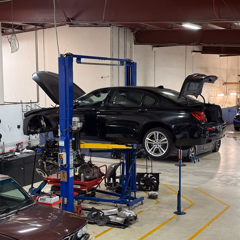 BMW on a lift in the BMT Workshop with the engine removed for service